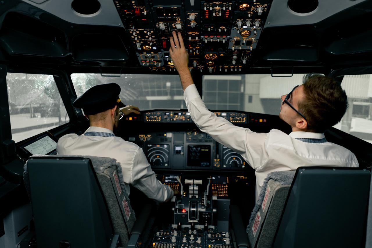 Two airline pilots in a cockpit , preparing for taxi